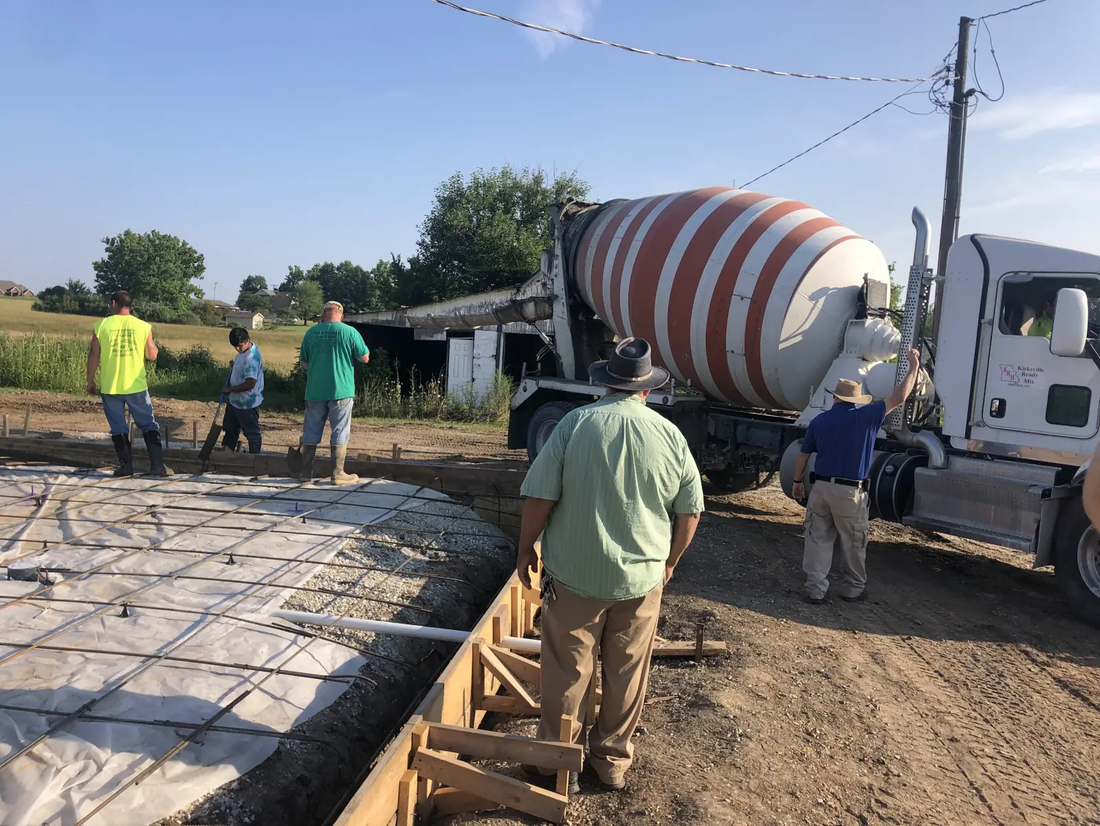 JHC crew pouring a reinforced concrete foundation with a Kirksville Ready Mix truck